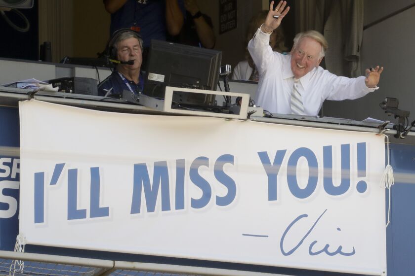Vin Scully, a Hall of Fame broadcaster who is in the final days of his 67-year career covering Los Angeles Dodgers baseball games, waves to the fans at Dodger Stadium before a baseball game against the Colorado Rockies in Los Angeles, Sunday, Sept. 25, 2016. (AP Photo/Chris Carlson)