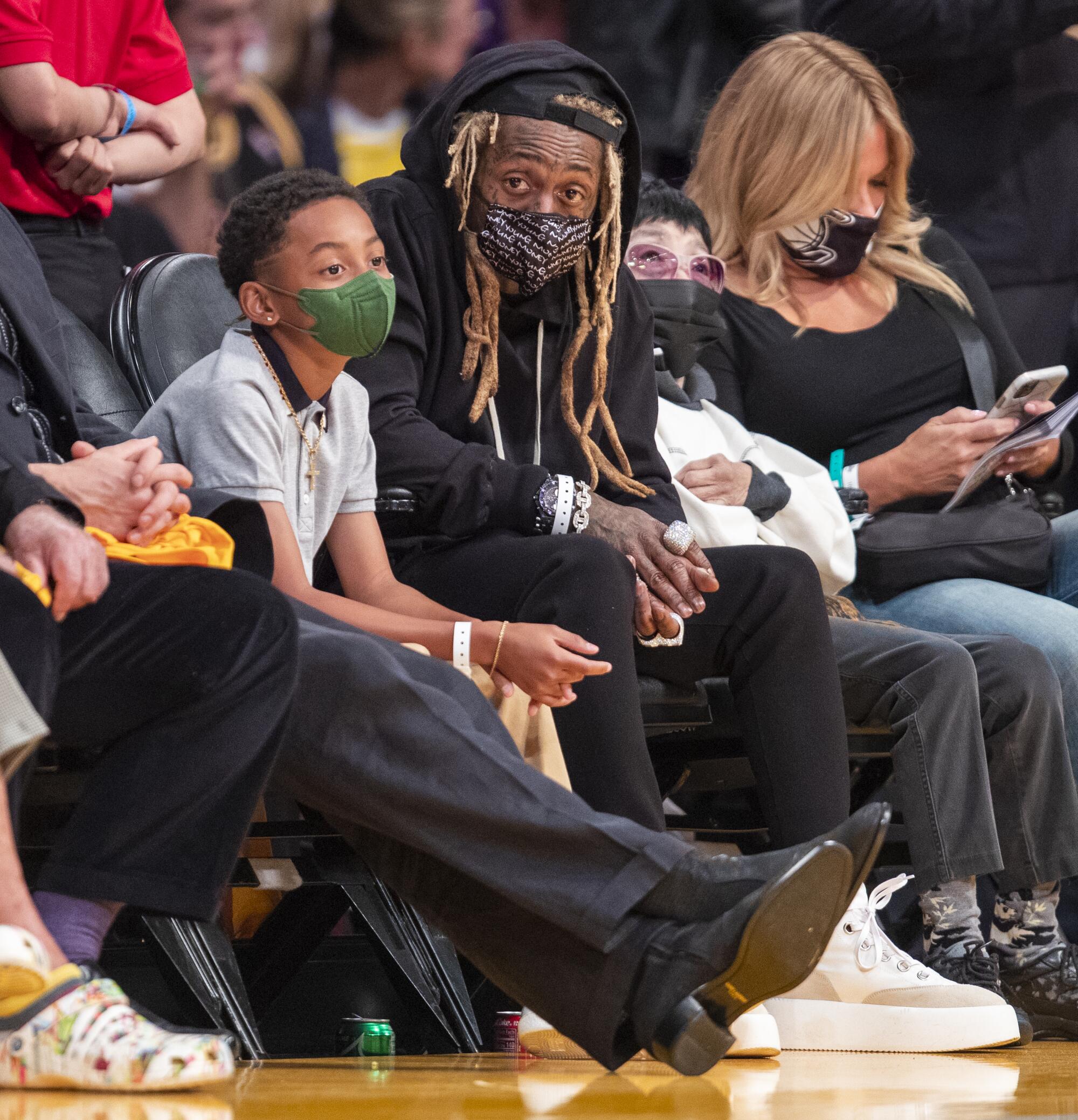 Lil Wayne and his son Kameron Carter watch the Lakers game.
