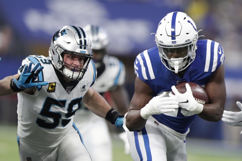 Indianapolis Colts running back Marlon Mack (25) runs past Carolina Panthers' Luke Kuechly (59) during the first half of an NFL football game, Sunday, Dec. 22, 2019, in Indianapolis. (AP Photo/Michael Conroy)