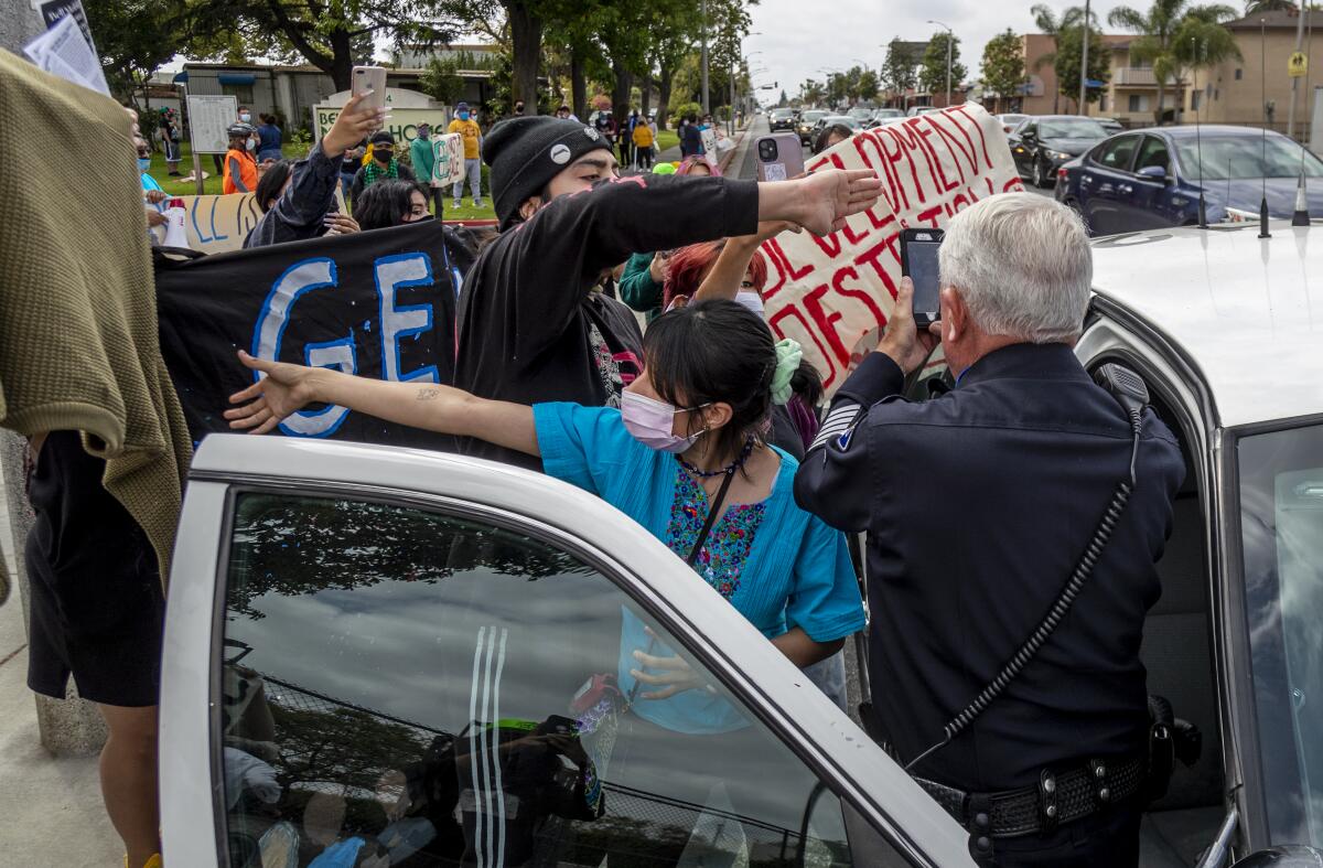 Activists block a police officer from videotaping