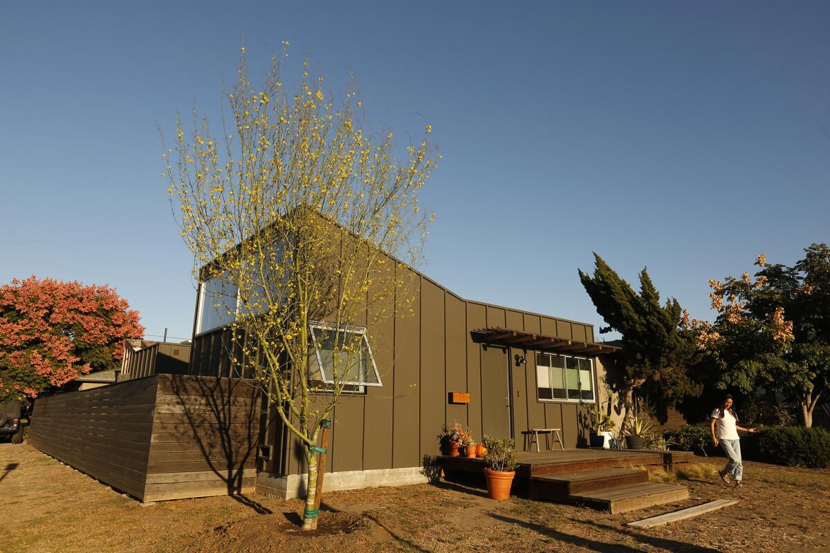 Homeowner Mai Hirai walks in the frontyard of her family's redesigned Mar Vista home. The home was redesigned by architect Talbot McLanahan. With the remodel done, landscaping will be the family's next task.