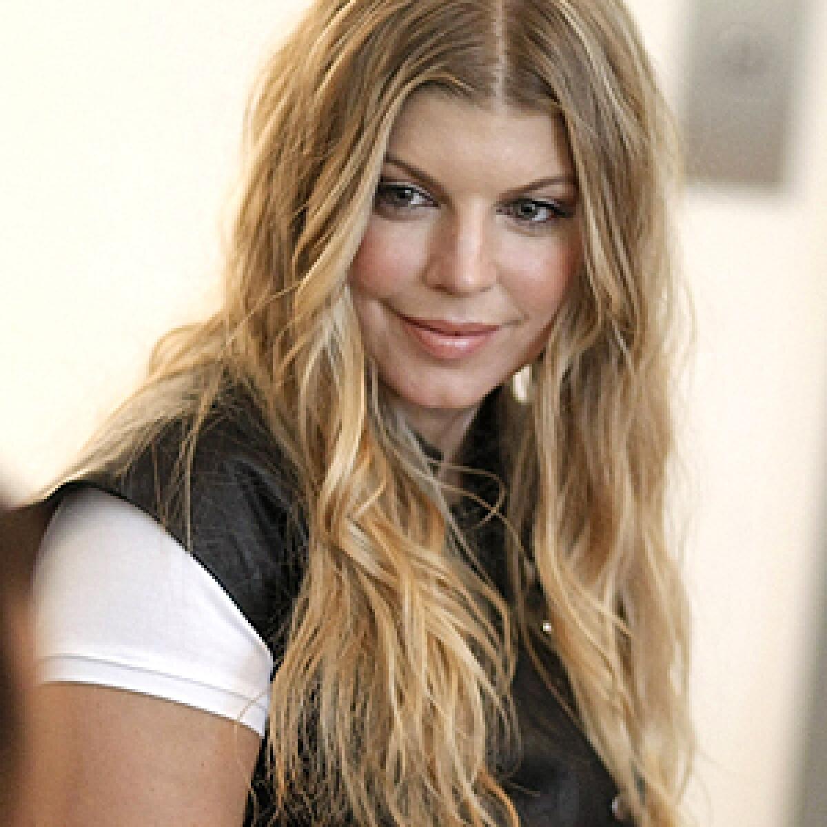 Fergie listens to stories from recipients of meals from the Project Angel Food program in Los Angeles.