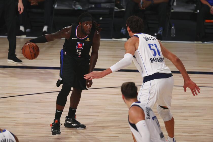 Los AngelesClippers forward Montrezl Harrell (5) controls the ball as Dallas Mavericks center Boban Marjanovic (51) defends during the second half of Game 1 of an NBA basketball first-round playoff series, Monday, Aug. 17, 2020, in Lake Buena Vista, Fla. (Kim Klement/Pool Photo via AP)