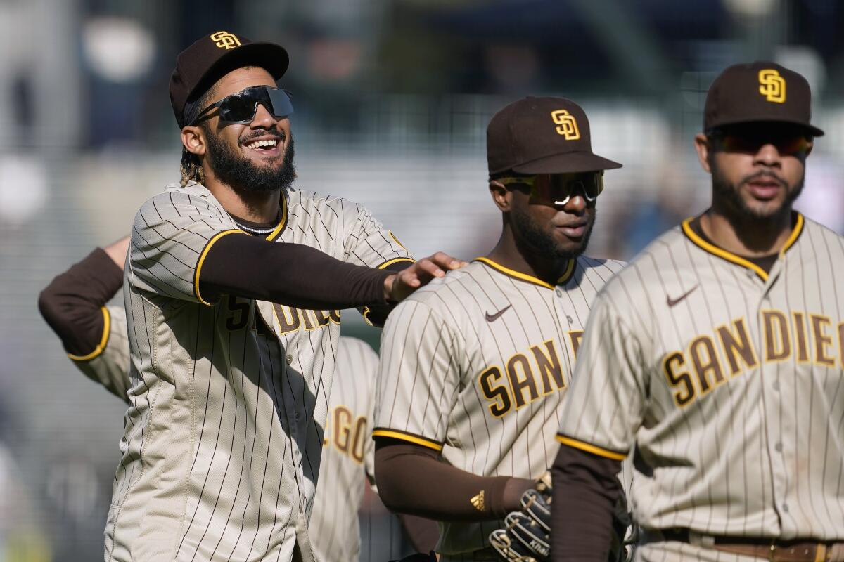 Fernando Tatis Jr., left, celebrates with Jurickson Profar and Tommy Pham, right, after the Padres beat the Giants