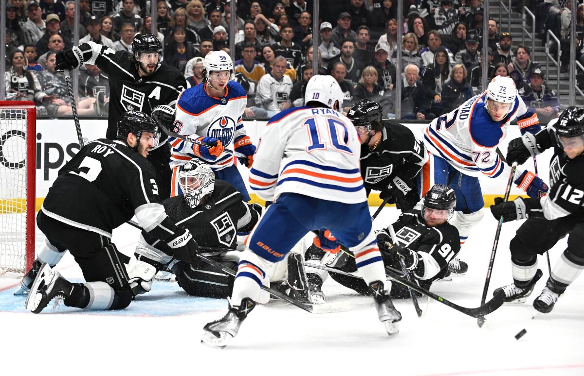 Kings players scramble as they try to keep the puck away from the Edmonton Oilers in overtime.