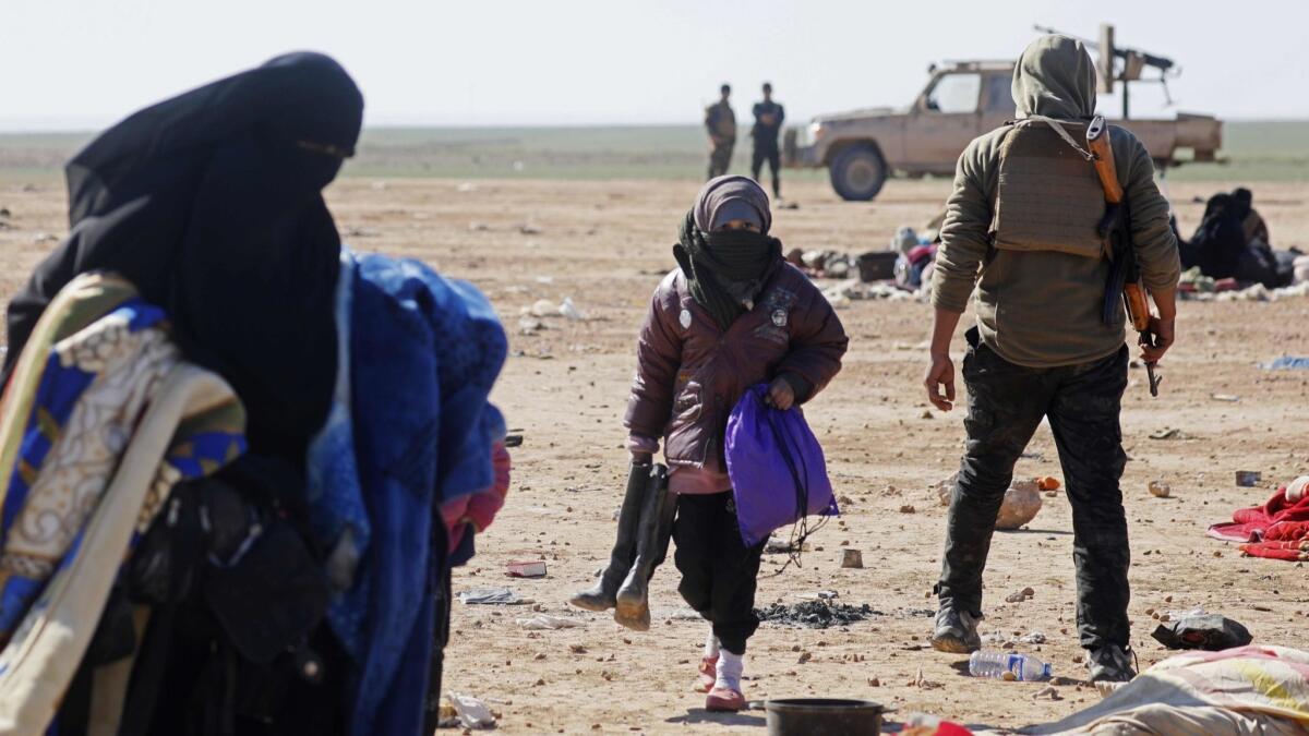 Civilians fleeing fighting between Syrian Democratic Forces and Islamic State in the Syrian village of Baghuz wait to be screened and registered by the U.S.-backed SDF in Deir Ezzor province on Sunday.