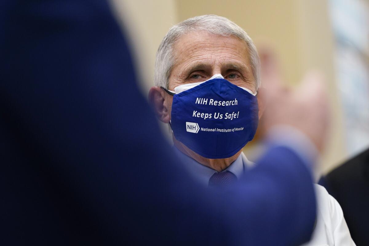 Dr. Anthony Fauci listens as President Joe Biden speaks