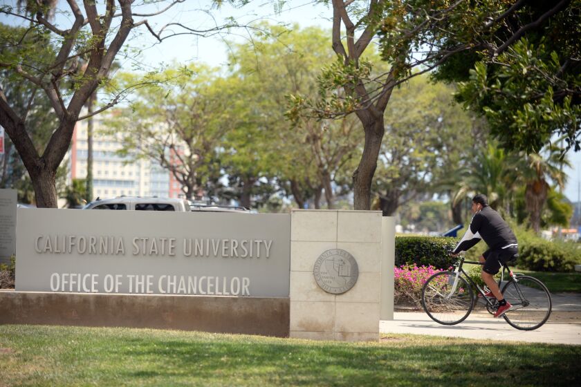 A bicyclist passes the California State University headquarters building in Long Beach.