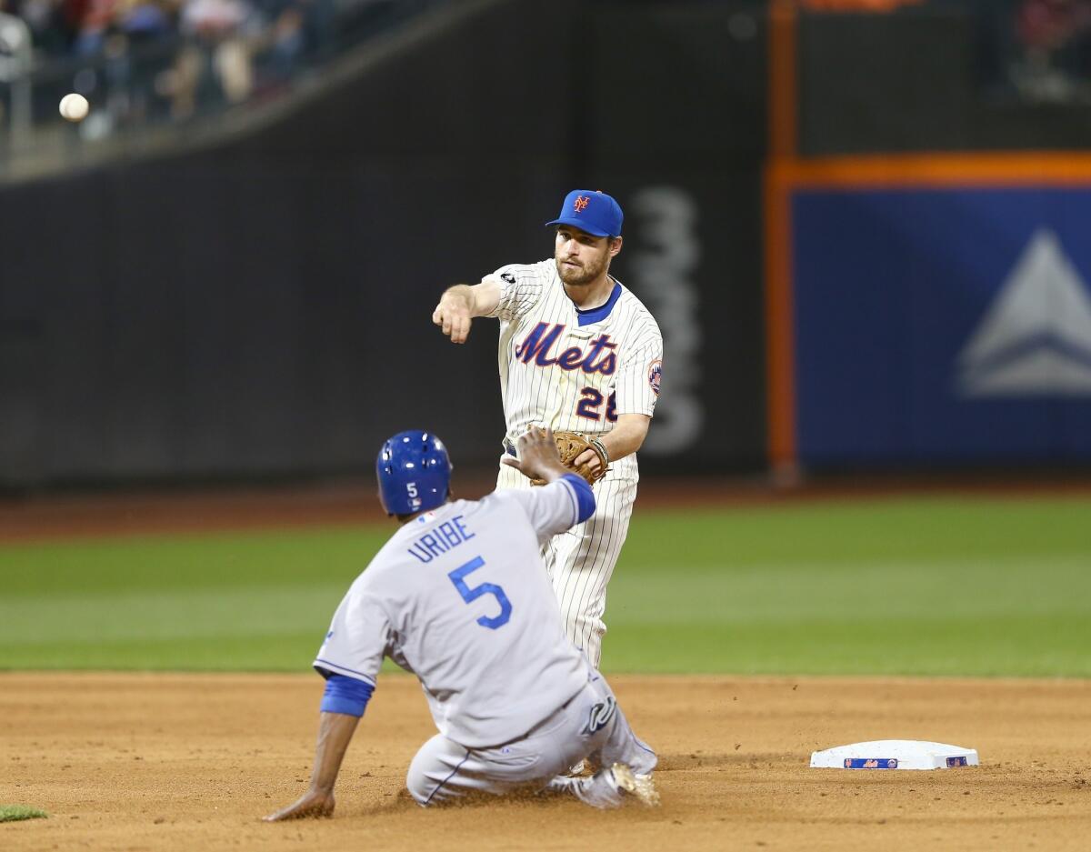 Daniel Murphy of the New York Mets turns the double play, getting the force out on Juan Uribe at second during the fifth inning. Uribe left Tuesday's game in the ninth inning with a strained right hamstring.