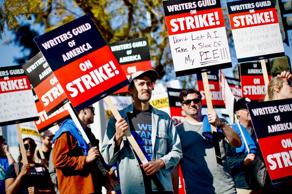 WGA writers walking a picket line with signs.