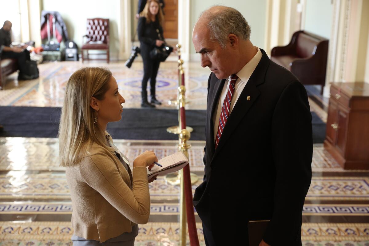 A woman and a man talk in the U.S. Capitol in Washington.