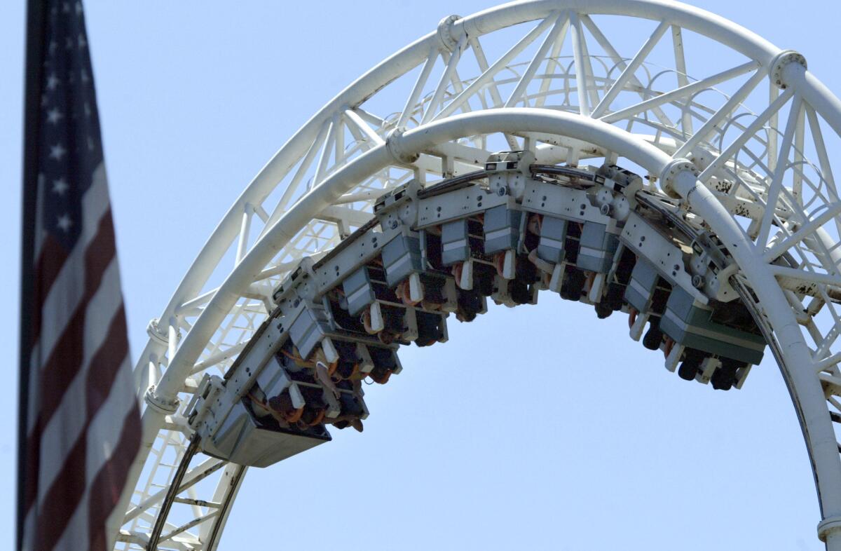 Park visitors take a spin on Revolution at Six Flags Magic Mountain in Valencia, Calif.