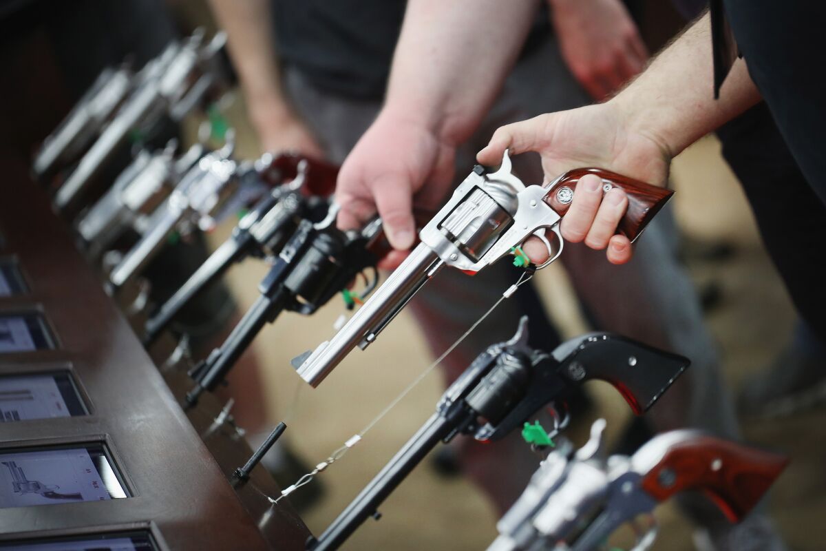 Gun enthusiasts look over Ruger pistols at the NRA annual meetings in May in Louisville, Ky.