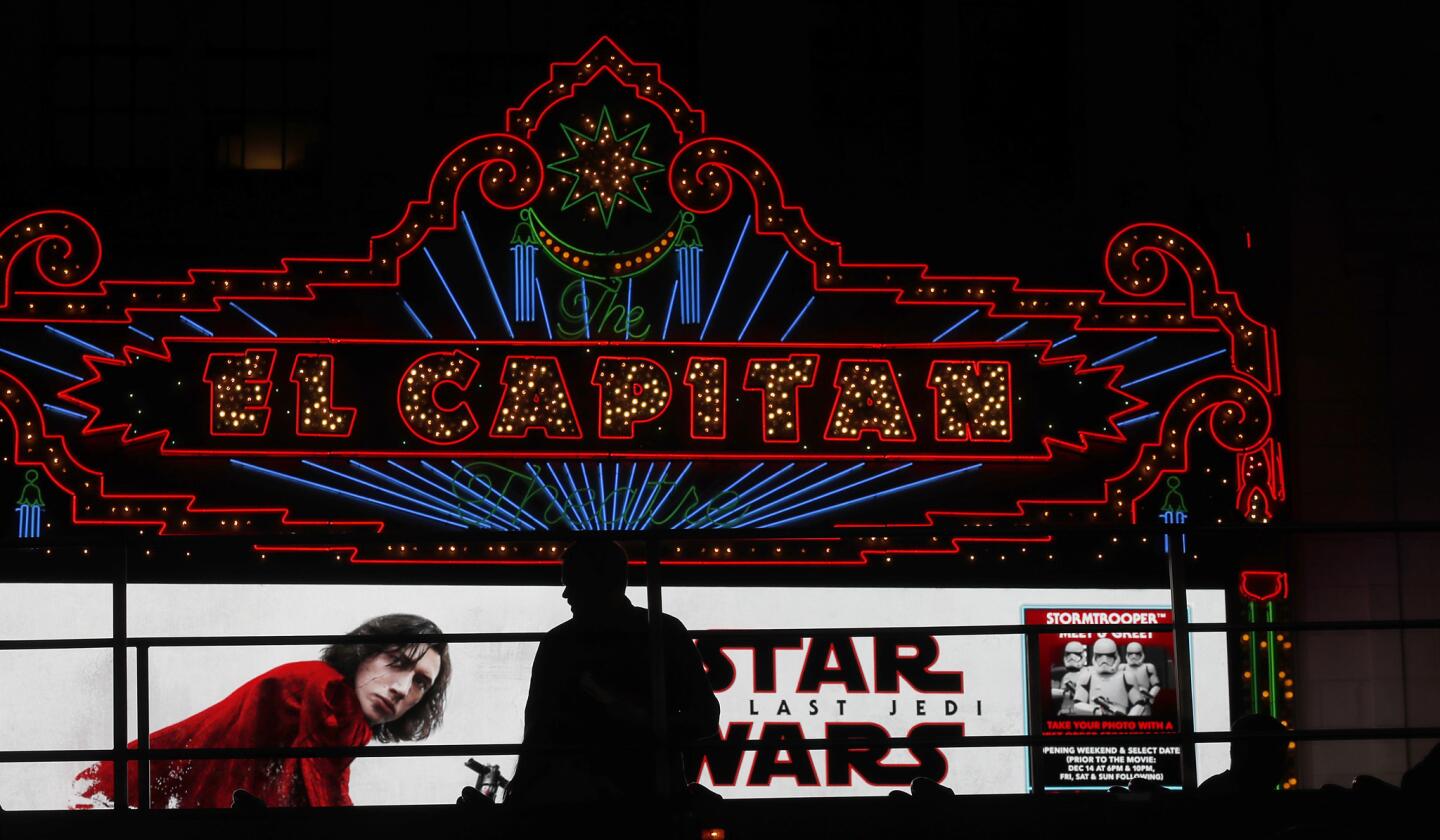 A passenger on the upper deck of a tour bus is silhoutted against the marquee of the El Capitan Theater in Hollywood, where "Star Wars: The Last Jedi" was screened.