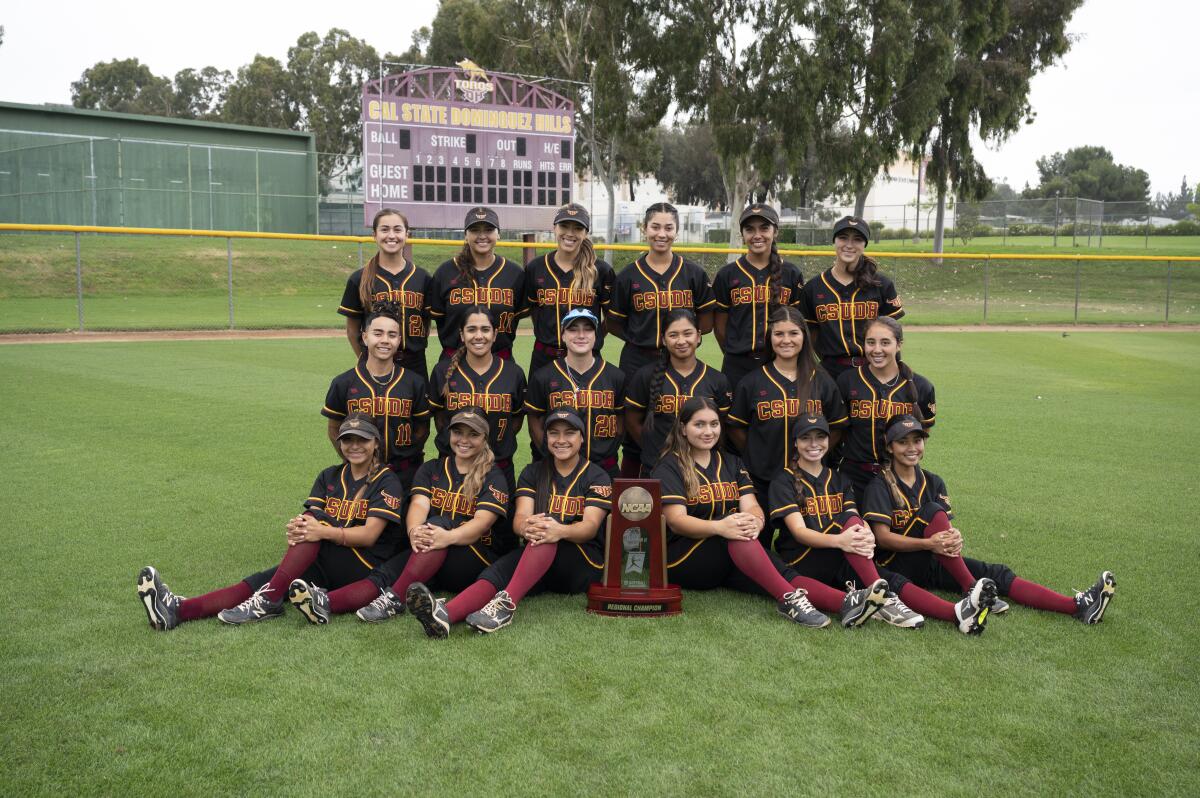 The Cal State Dominguez Hills softball team gathers with the NCAA Division II West Region trophy.