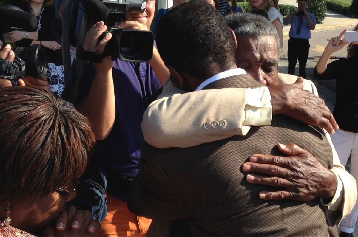 James McCollum, facing camera, embraces his son Henry following the younger man's release from Central Prison in Raleigh, N.C., on Wednesday after 30 years on death row for a murder he did not commit.