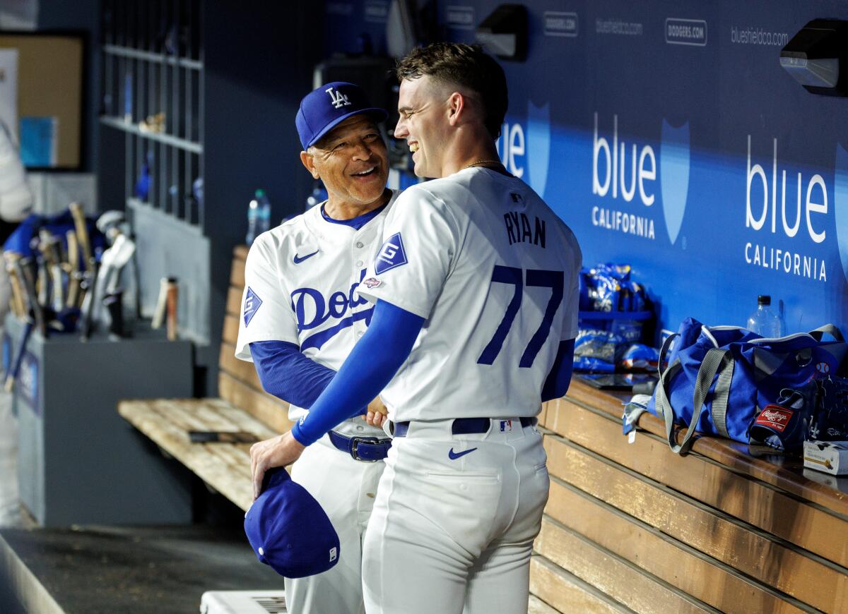 Dodgers manager Dave Roberts congratulates pitcher River Ryan after his strong major league debut against the Giants.