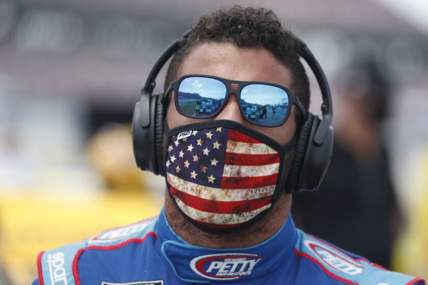 Driver Bubba Wallace walks to his car in the pits of the Talladega Superspeedway prior to the start of the NASCAR Cup Series auto race at the Talladega Superspeedway in Talladega Ala., Monday June 22, 2020. In an extraordinary act of solidarity with NASCAR’s only Black driver, dozens of drivers pushed the car belonging to Bubba Wallace to the front of the field before Monday’s race as FBI agents nearby tried to find out who left a noose in his garage stall over the weekend. (AP Photo/John Bazemore)