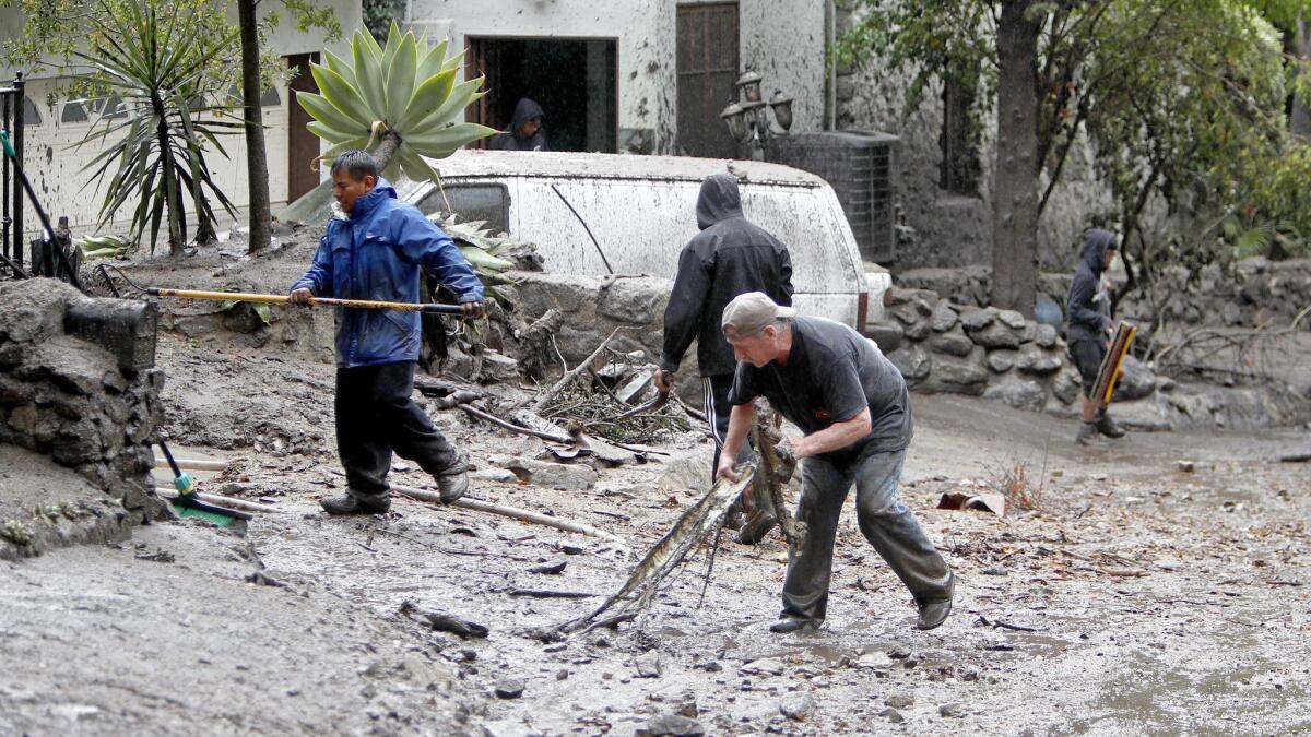 Residents removed mud from their home on Country Club Drive in 2018 after a rainstorm brought of torrent of debris down the street. A similar storm is expected to hit the area on Tuesday.