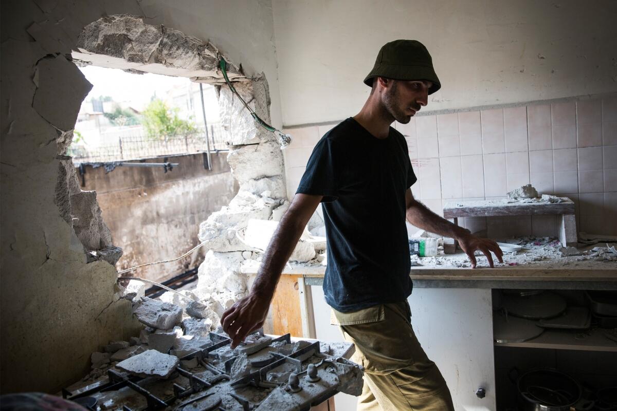 An Israeli soldier inspects an Israeli home allegedly hit by a Hamas rocket in Sderot, Israel.