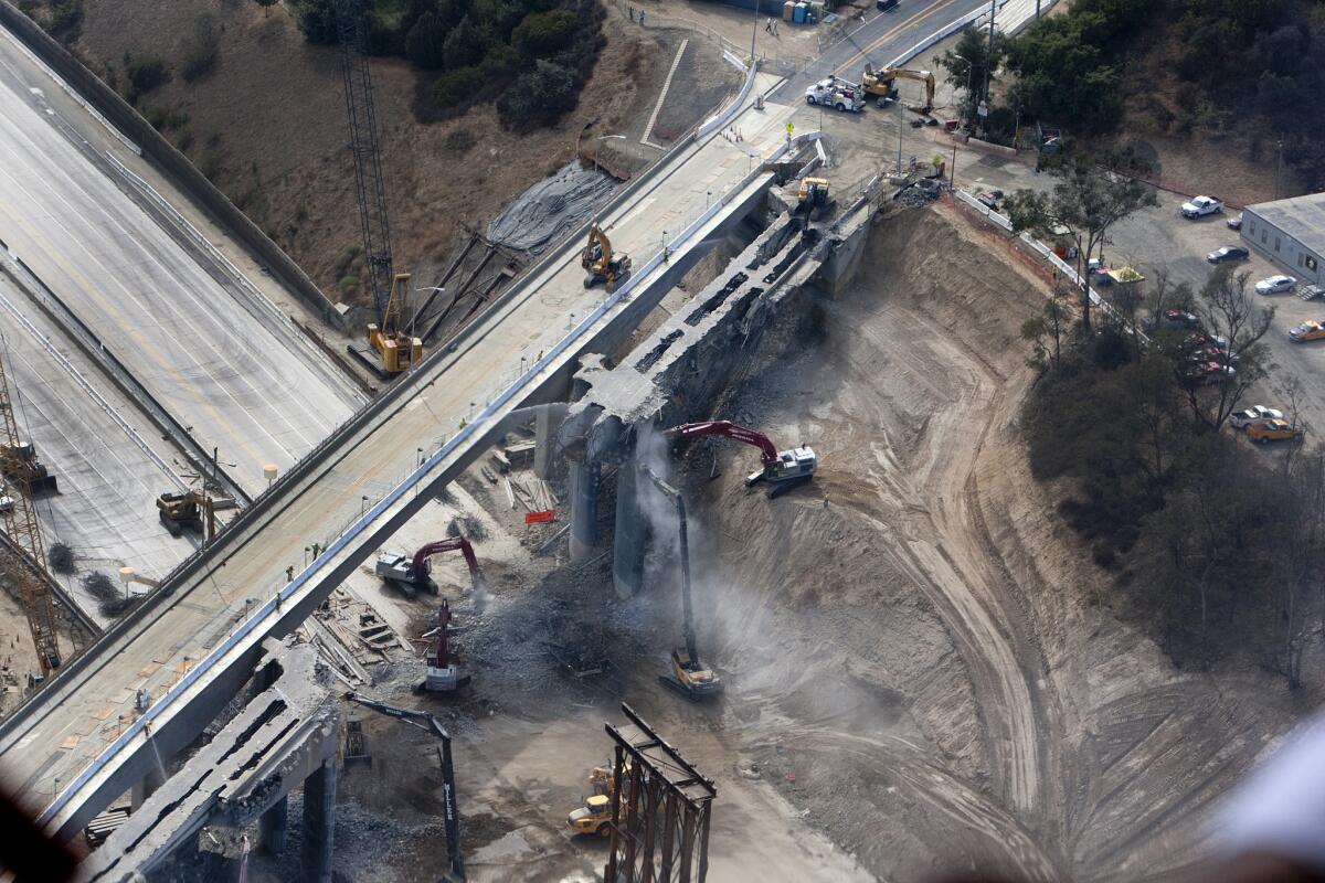 Construction crews demolish the north side of the Mulholland Bridge over the closed 405 Freeway in 2012, part of the long-running project to add a carpool lane to the freeway.