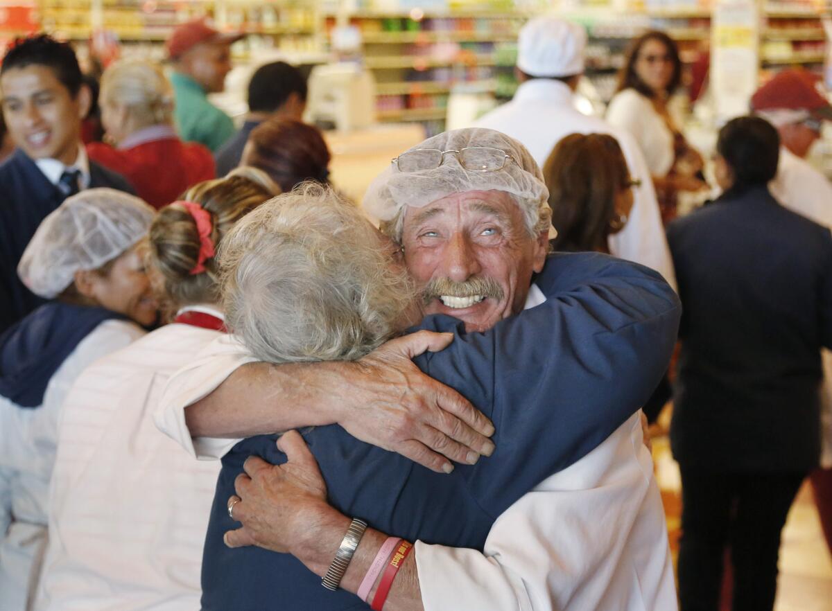 Meat department manager Bob Dietz hugs cashier Mary Olson after watching a televised speech by restored Market Basket CEO Arthur T. Demoulas at a store in Chelsea, Mass.