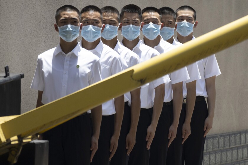 Security personnel wearing face masks line up outside the former United States Consulate in Chengdu in southwest China's Sichuan province on Monday, July 27, 2020. Chinese authorities took control of the former U.S. consulate in the southwestern Chinese city of Chengdu on Monday after it was ordered closed in retaliation for a U.S. order to vacate the Chinese Consulate in Houston. (AP Photo/Ng Han Guan)