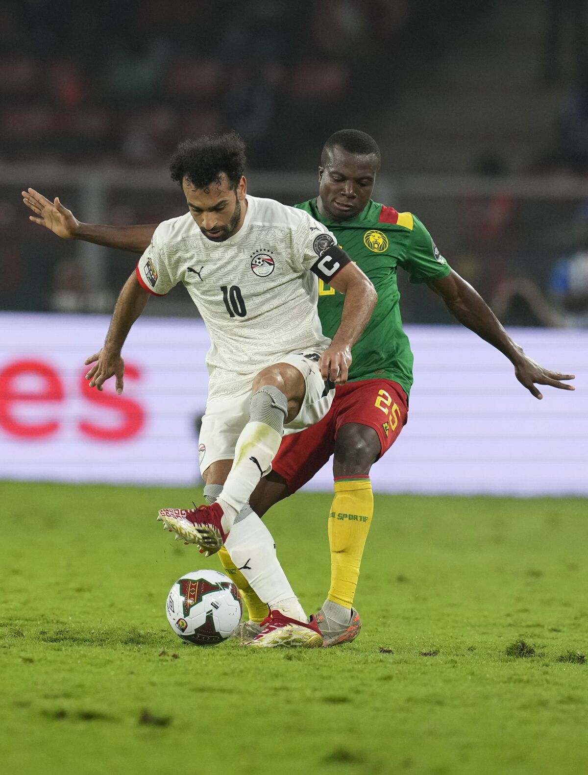 Egypt's Mohamed Salah, left, is challenged by Cameroon's Nouhou Tolo during the African Cup of Nations 2022 semi-final soccer match between Cameroon and Egypt at the Olembe stadium in Yaounde, Cameroon, Thursday, Feb. 3, 2022. (AP Photo/Themba Hadebe)
