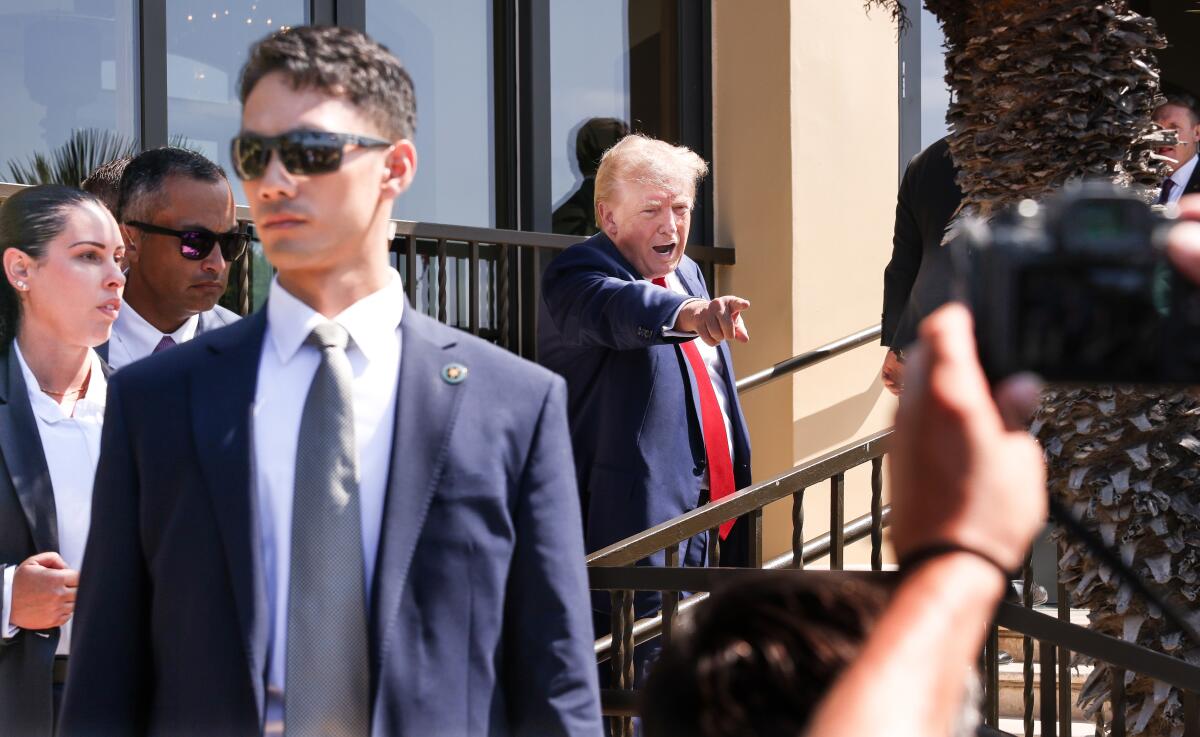 Donald Trump leaves the news conference at his Trump National Golf Club on Friday.