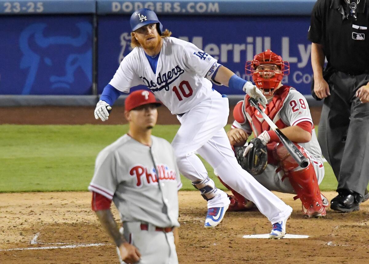 Dodgers third baseman Justin Turner drops his bat after hitting a two-run home run off Phillies pitcher Vince Velasquez, left, during the fourth inning.