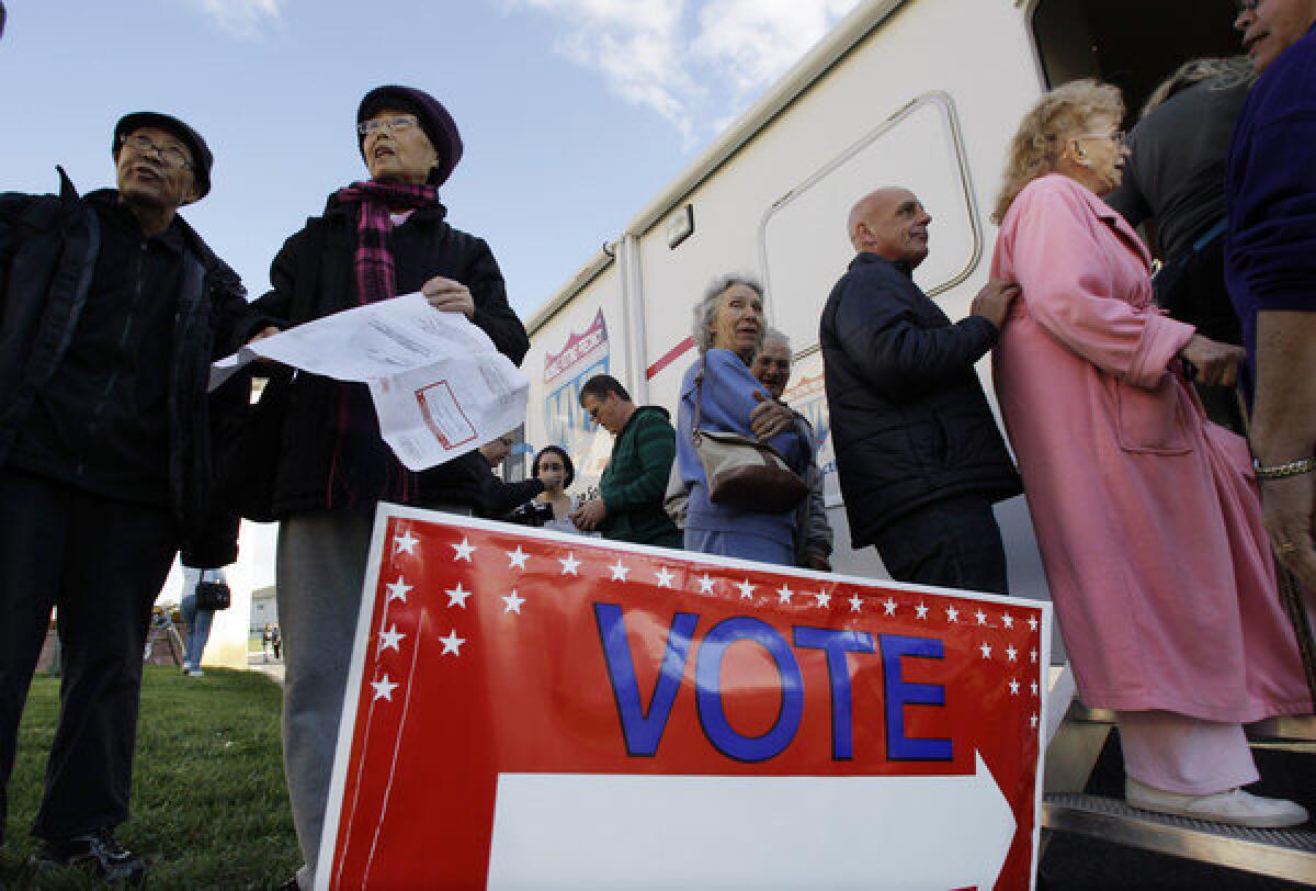 Voters stand together in Burlington, N.J., outside a Mobile Voting Precinct, as they inquire about voting. Many victims displaced by Superstorm Sandy took advantage of offers to vote early.