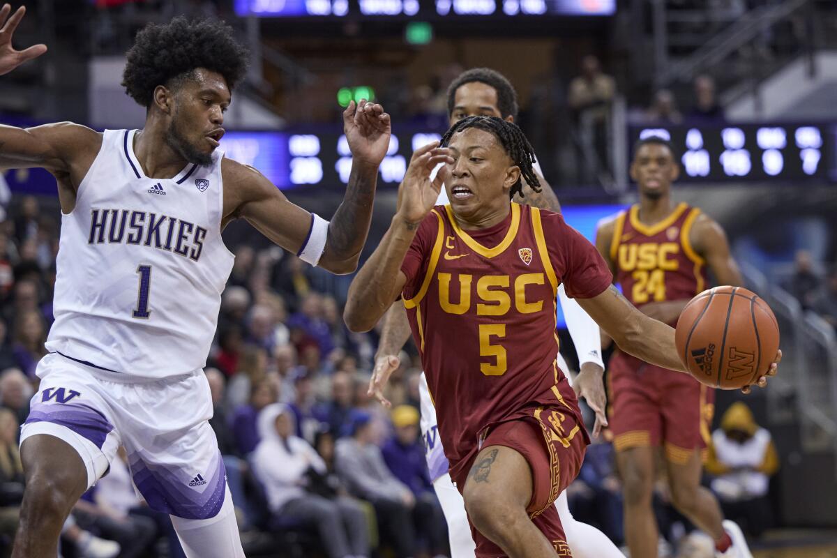 USC's Boogie Ellis drives against Washington's Keion Brooks on Dec. 30, 2022.