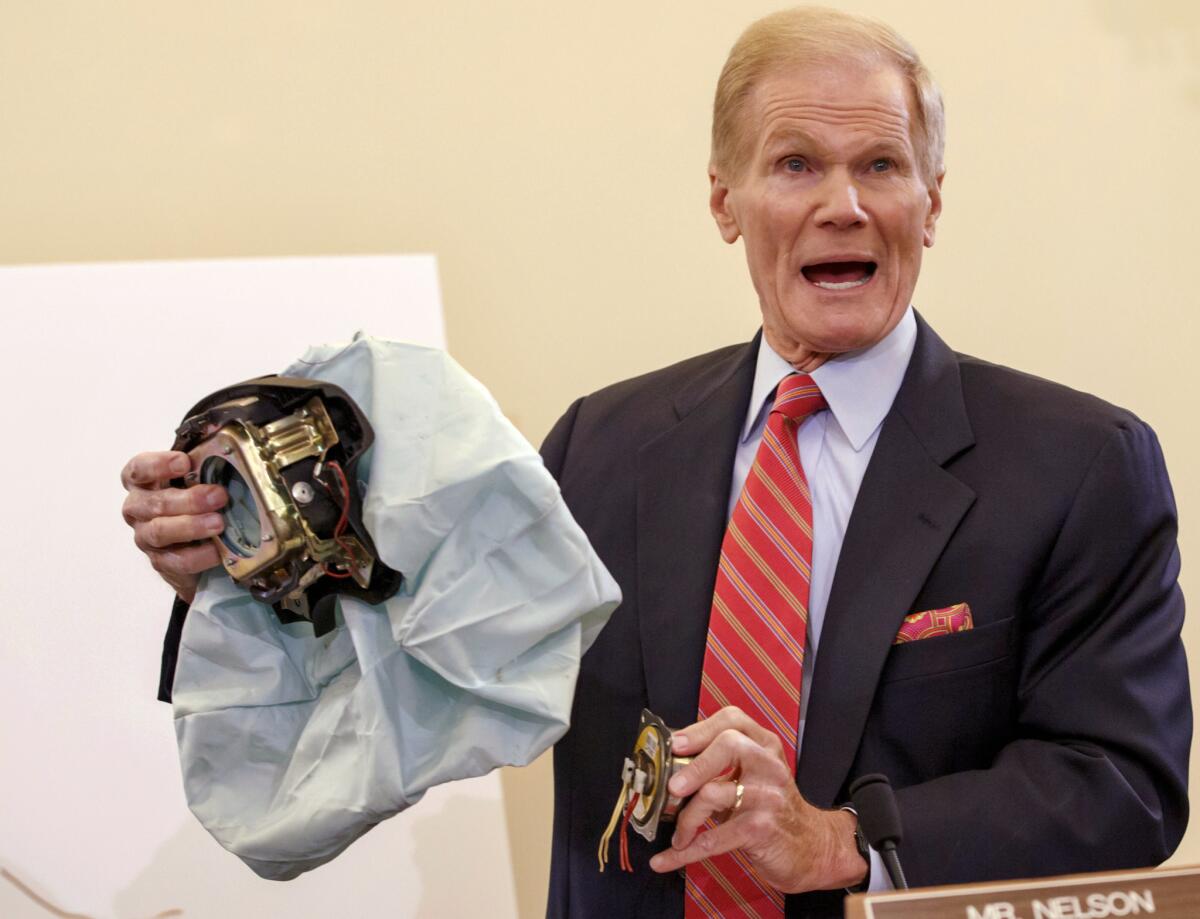 Sen. Bill Nelson (D-Fla.), shown in 2014 with a Takata air bag, wants automakers to replace the potentially deadly inflators before the cars are sold so they don't have to be recalled.