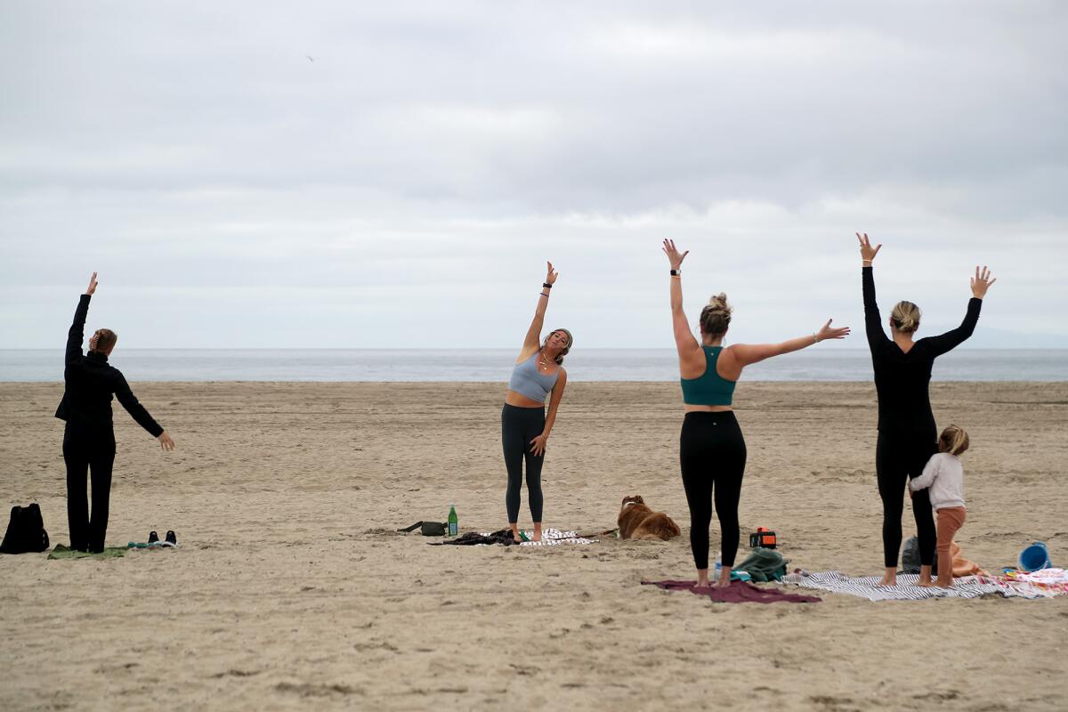 Yoga instructor Chelsey Lowe, center, with Gryffin resting by her side, teaches an outdoor yoga class.