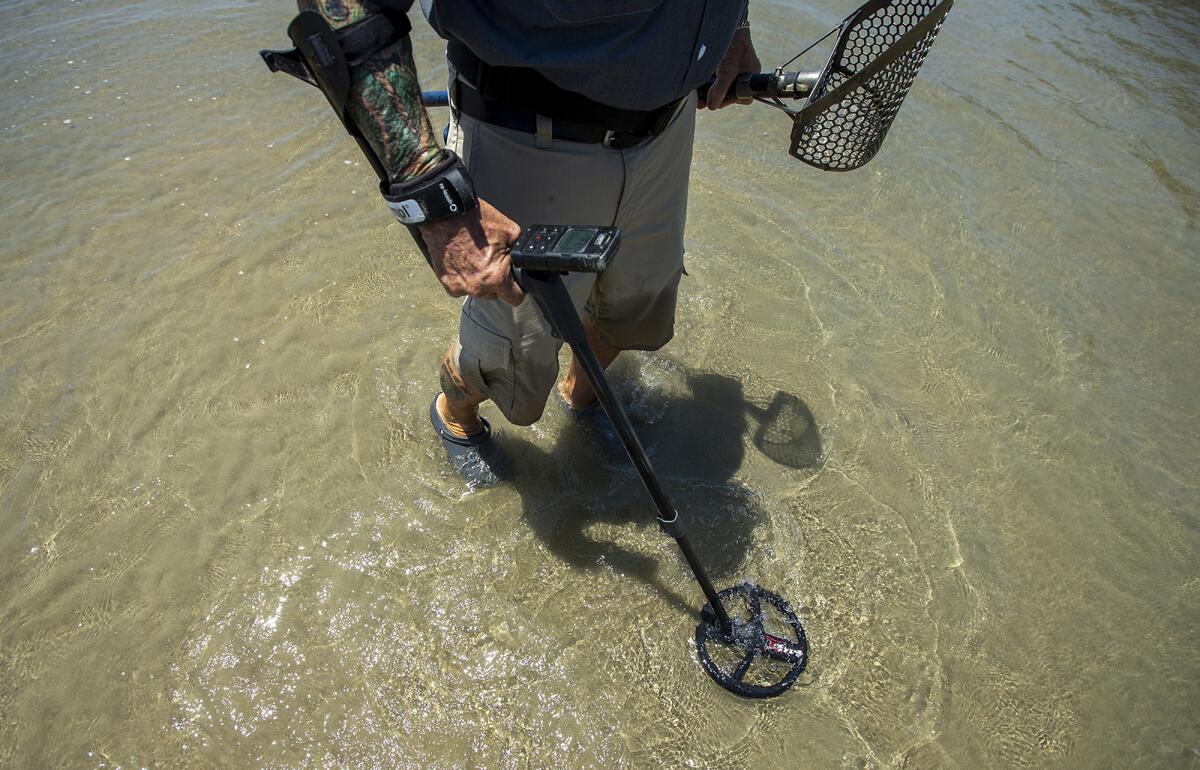 Stan Ross, 79, searches for metal near the Newport Beach Pier on Wednesday.