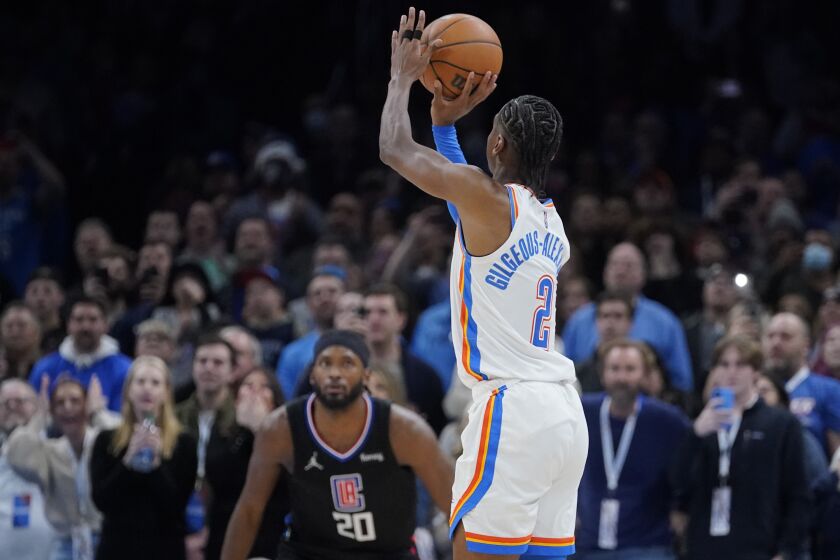 Oklahoma City Thunder guard Shai Gilgeous-Alexander (2) shoots a game-winning 3-point shot in front of Los Angeles Clippers forward Justise Winslow (20) at the end of an NBA basketball game, Saturday, Dec. 18, 2021, in Oklahoma City. (AP Photo/Sue Ogrocki)