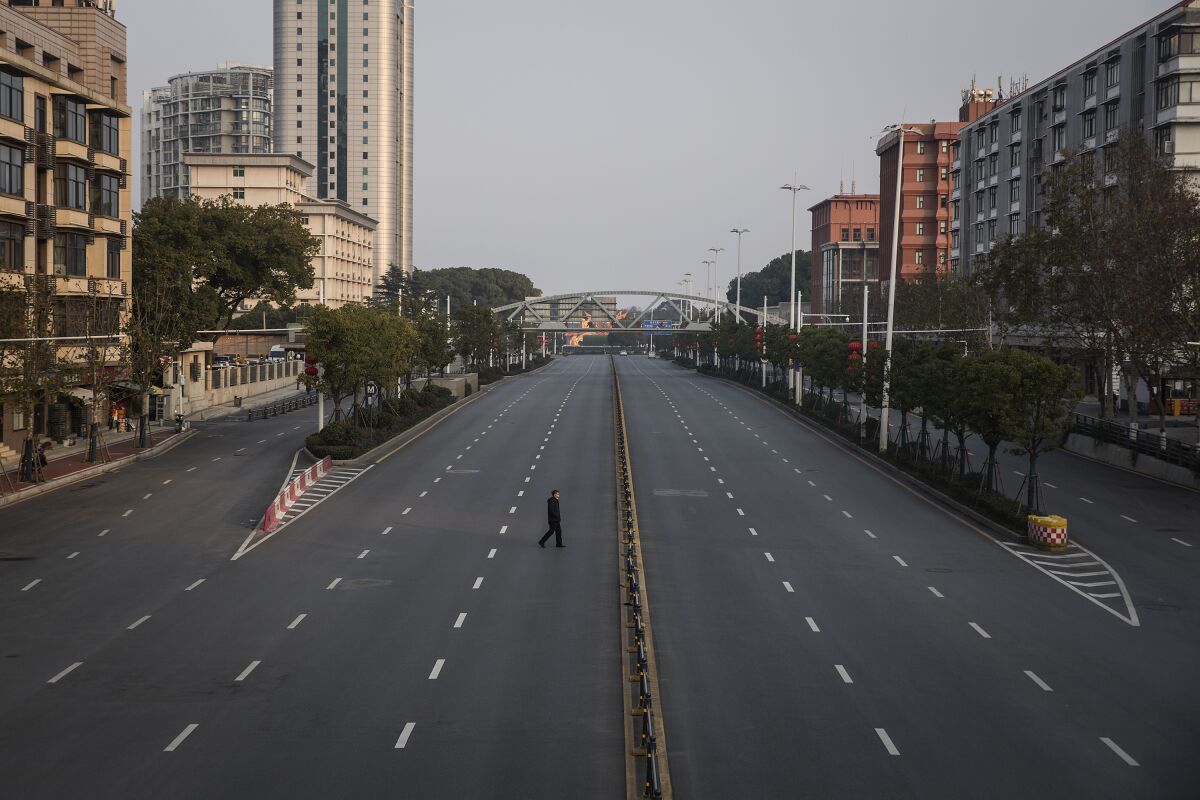 A man crosses an empty highway on Feb. 3, 2020, in Wuhan, China, the epicenter of the global coronavirus outbreak.