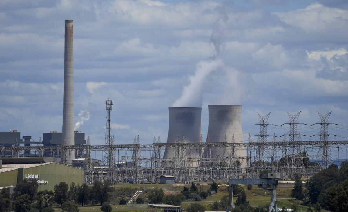FILE - The Liddell Power Station, left, and Bayswater Power Station, coal-powered thermal power station are pictured near Muswellbrook in the Hunter Valley, Australia on Nov. 2, 2021. Australia's Senate has voted, Thursday, Sept. 8, 2022, to ensure the government's elevated target of reducing greenhouse gas emissions by 43% below 2005 levels by the end of the decade is enshrined in law. (AP Photo/Mark Baker, File)