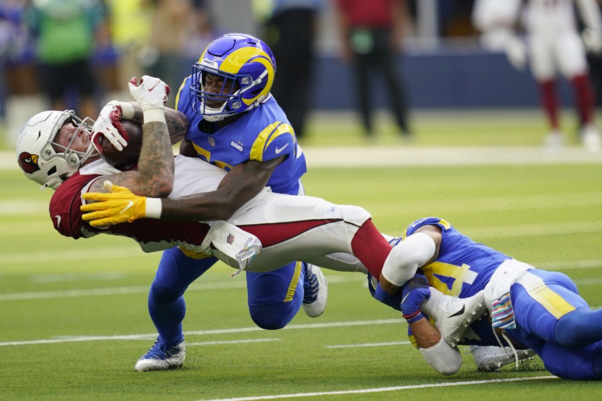 Arizona Cardinals tight end Maxx Williams is tackled by Los Angeles Rams linebacker Ernest Jones, top center, and safety Taylor Rapp, right, during the first half in an NFL football game Sunday, Oct. 3, 2021, in Inglewood, Calif. (AP Photo/Ashley Landis )