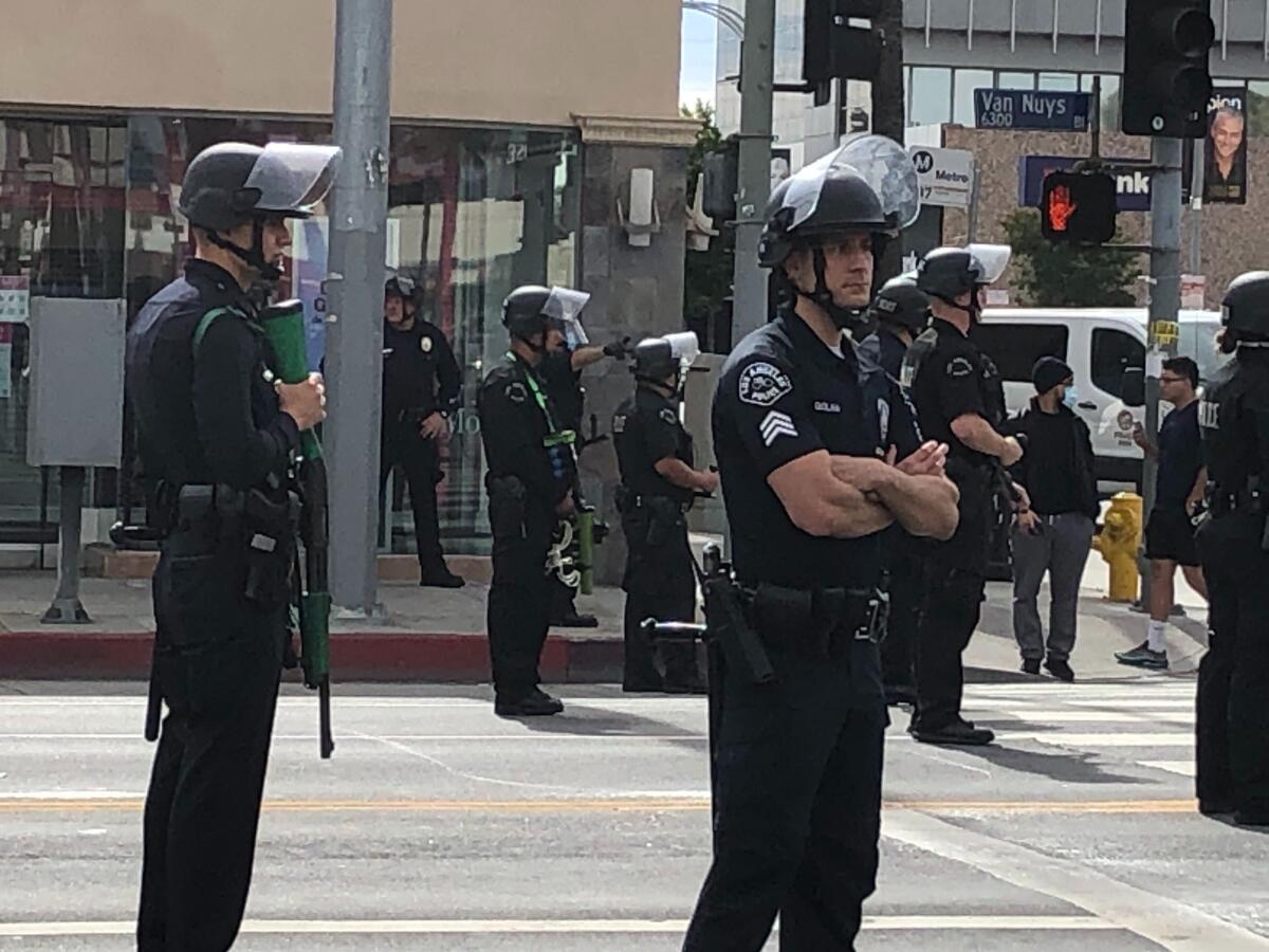 LAPD officers watch a peaceful protest in Van Nuys in June 2020. 