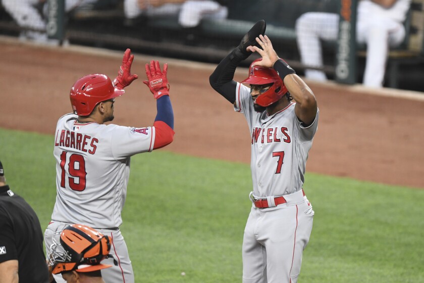 The Angels' Juan Lagares (19) is greeted by Angels fielder Jo Adell (7) after hitting a two-run home run
