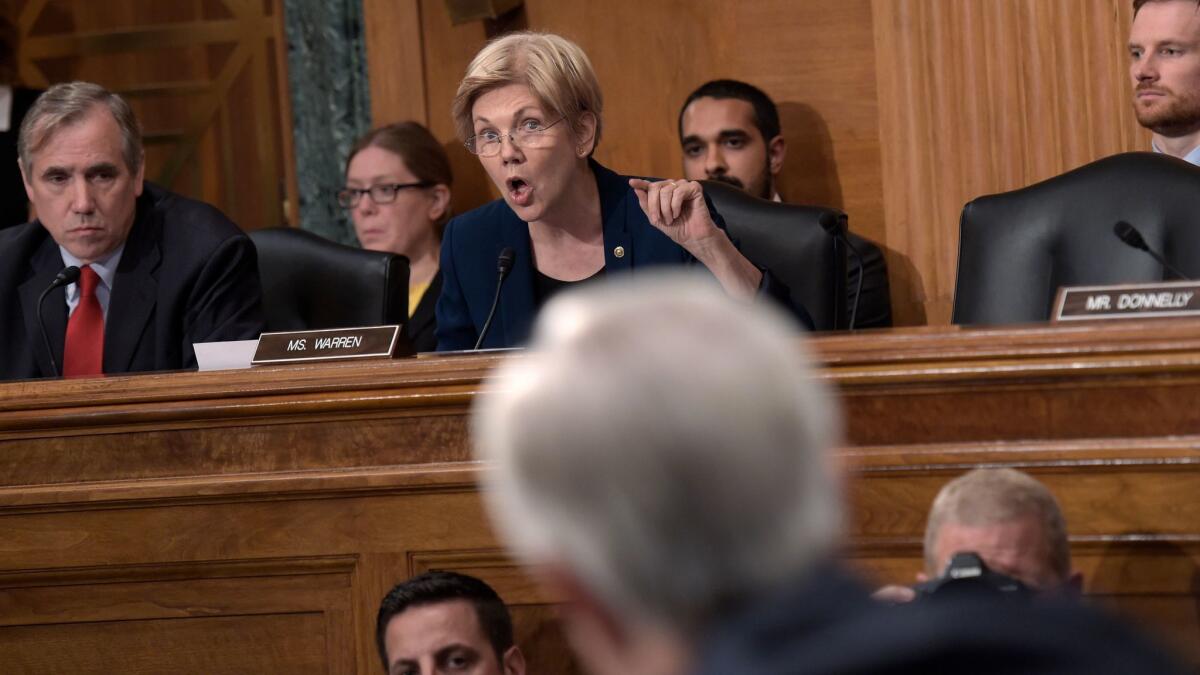 Sen. Elizabeth Warren, D-Mass., rips into then-Wells Fargo CEO John Stumpf, foreground, during hearings last year on the bank's consumer account scandal. Stumpf resigned a few weeks later, but board members who allowed the scandal to proceed are still in their posts.