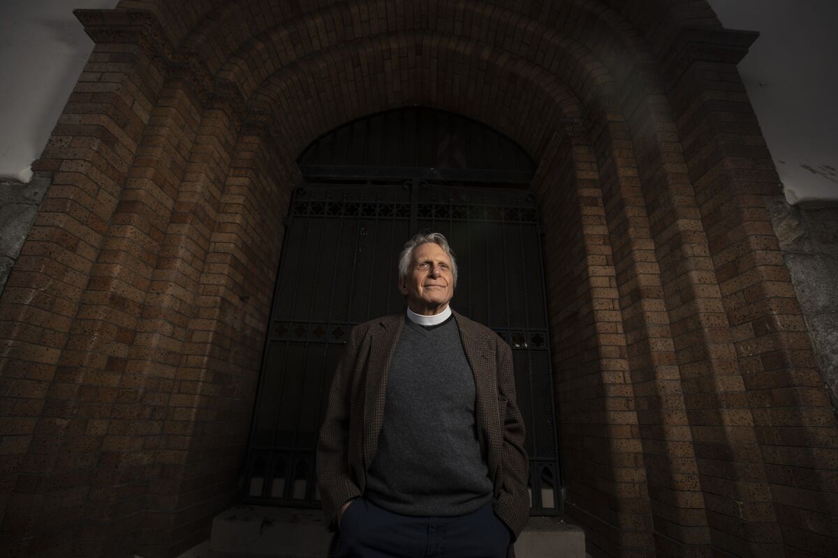 Father Thomas Carey stands in a brick archway