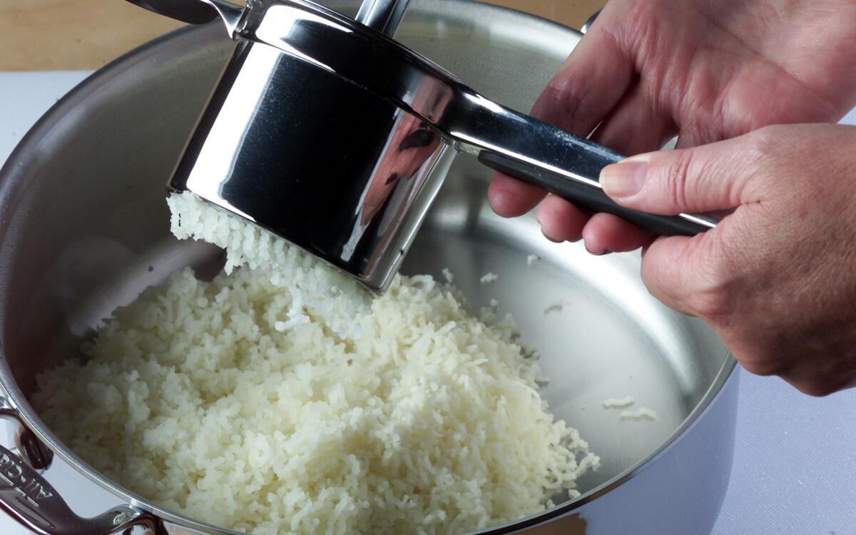 Potatoes are extruded from a ricer for fluffiest mashed potatoes.