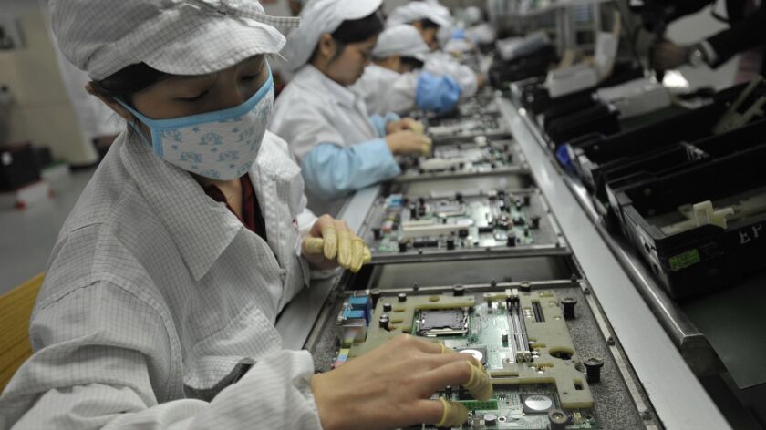 Chinese workers assemble equipment in a Foxconn factory in Shenzhen, China. Foxconn supplies parts to Apple and other American tech companies.
