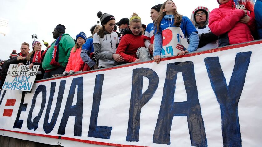 Fans push for equal pay for the women's soccer team during an international friendly soccer match between the United States and Colombia in East Hartford, Conn., in April.
