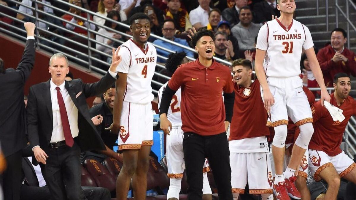 USC forward Bennie Boatwright, center, celebrates a Trojans three-pointer with his teammates during a game against UCLA at Galen Center on Jan. 25.