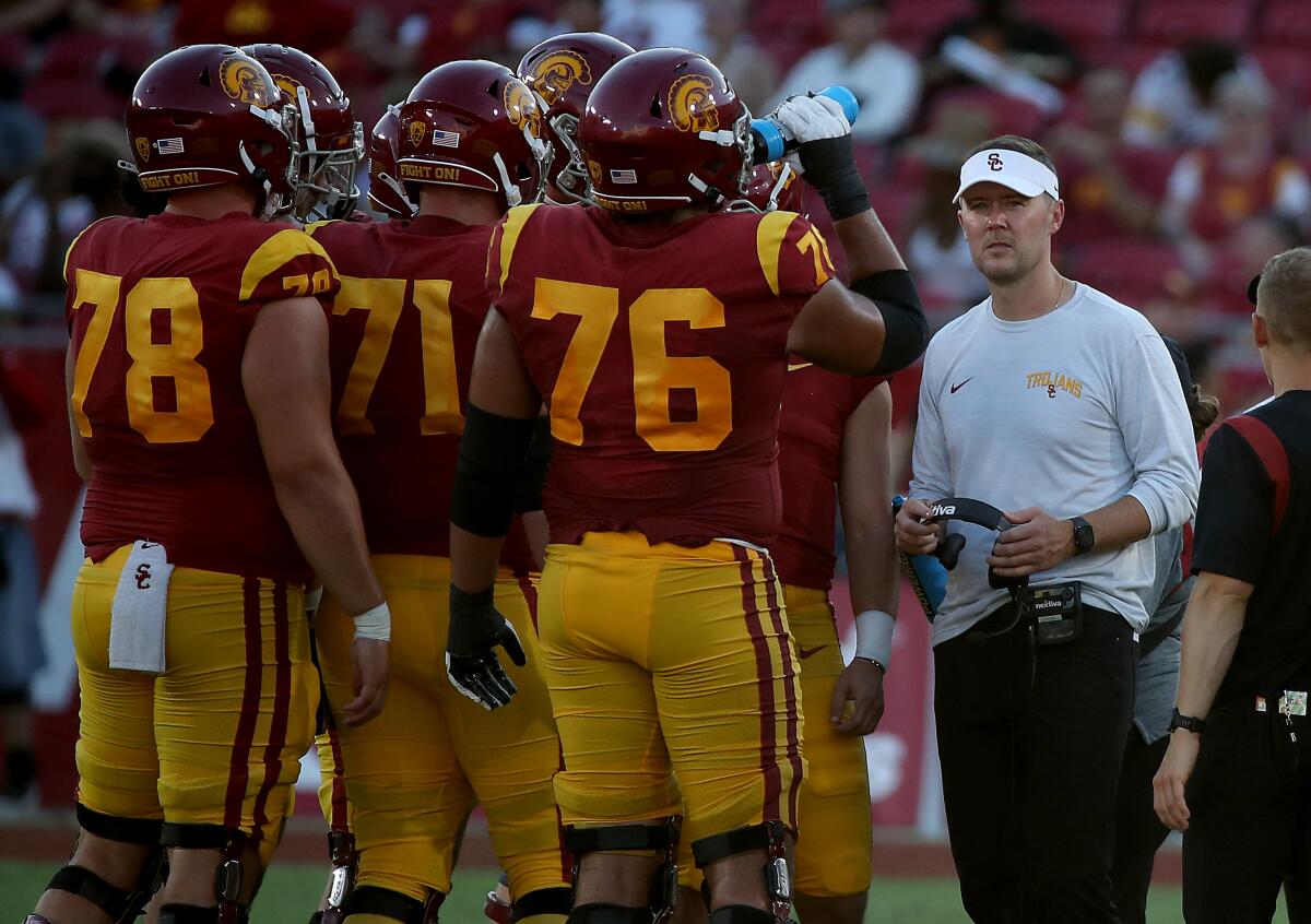 USC coach Lincoln Riley huddles with his players during a break in the game against Rice at the Coliseum
