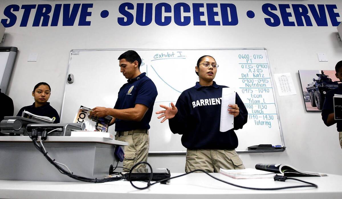 Eduardo Serrano and Christina Barrientos make a presentation during an economics class in the Police Orientation Preparation Program, which allows 12th-graders to earn their high school diplomas and work toward an associate’s degree as they prepare for a law enforcement career.