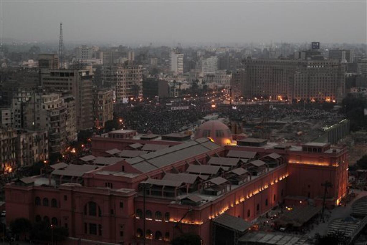 Seen over the roofs of the Egyptian Museum, a crowd remains late afternoon in Tahrir, or Liberation, Square in Cairo, Egypt, Tuesday, Feb. 1, 2011. More than a quarter-million people flooded into the heart of Cairo Tuesday, filling the city's main square in by far the largest demonstration in a week of unceasing demands for President Hosni Mubarak to leave after nearly 30 years in power. (AP Photo/Lefteris Pitarakis)
